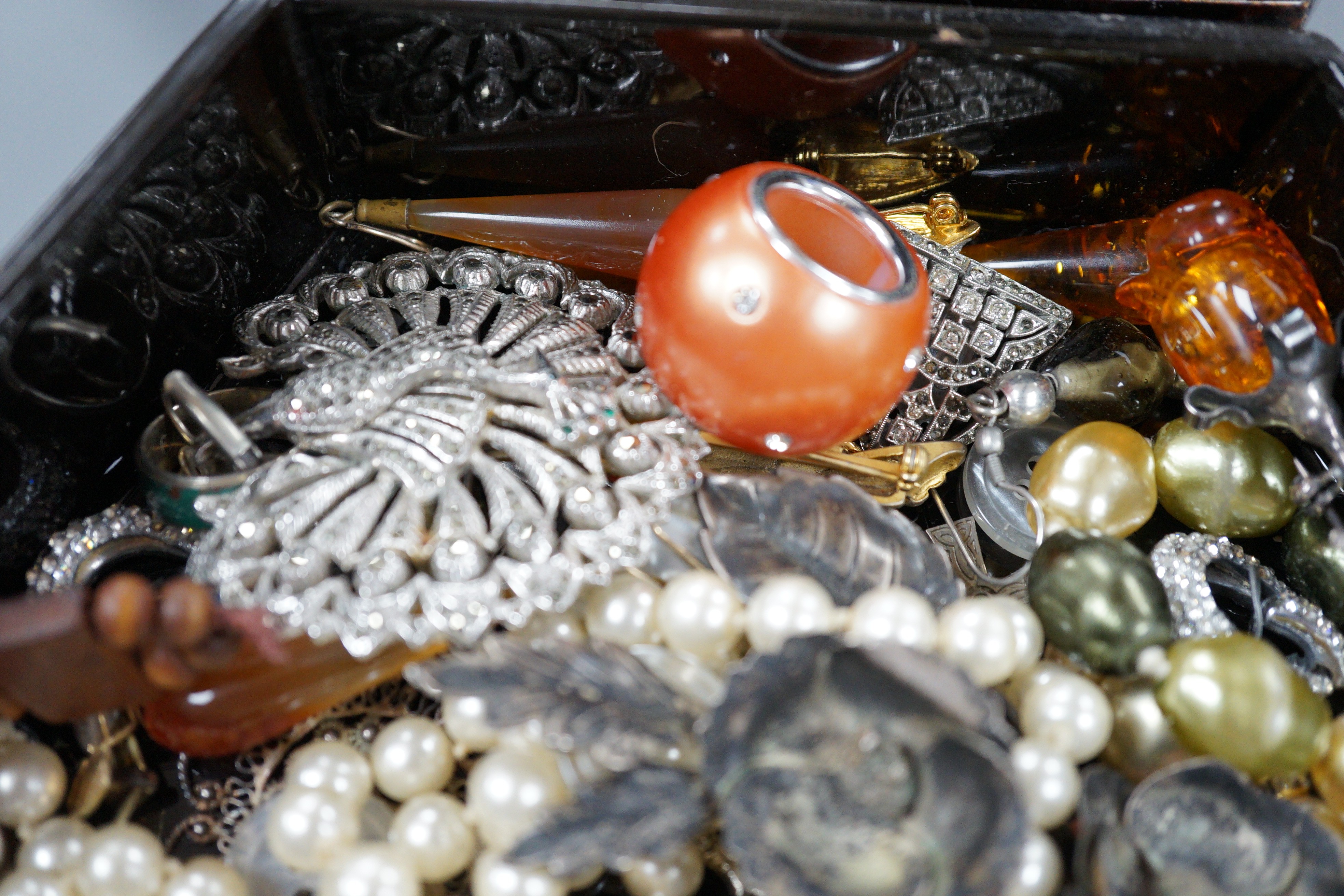 A quantity of assorted costume jewellery in a lacquer box.